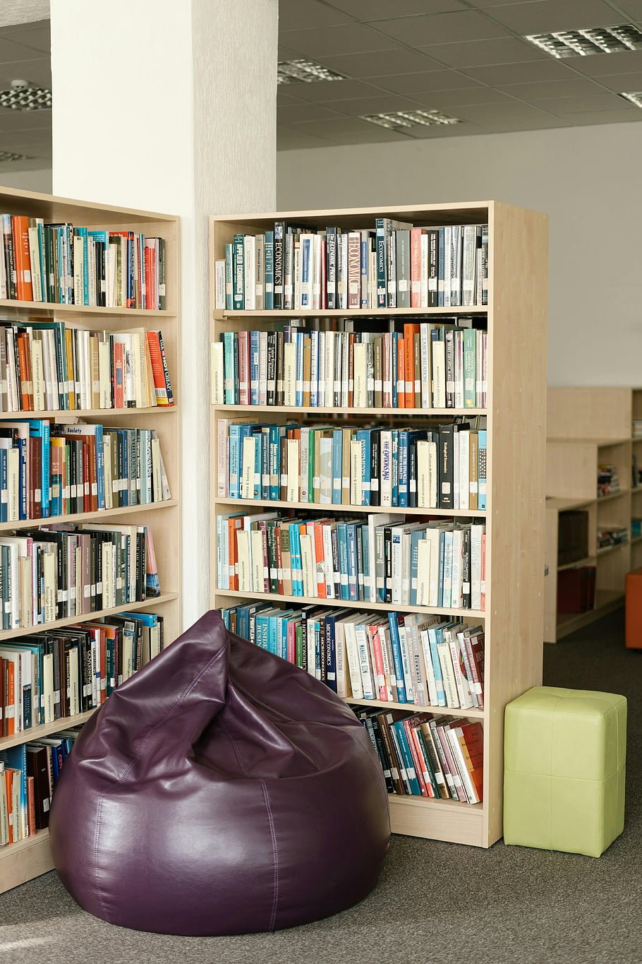 Purple bean bag in a cozy reading area surrounded by bookshelves